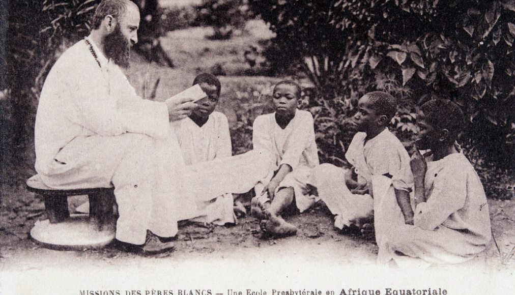 Missionnaire en Afrique : un membre de la société missionnaire des Pères Blancs enseignant à des enfants dans une école d'Afrique équatoriale. Carte postale des années 1930 ©Collection Sirot-Angel/leemage Missionnaire en Afrique : un membre de la société missionnaire des Pères Blancs enseignant à des enfants dans une école d'Afrique équatoriale. Carte postale des années 1930 ©Collection Sirot-Angel/leemage / © Wikimedia Commons